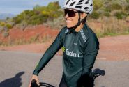 A woman cyclist enjoying a ride on a sunny day, wearing sports gear and helmet.